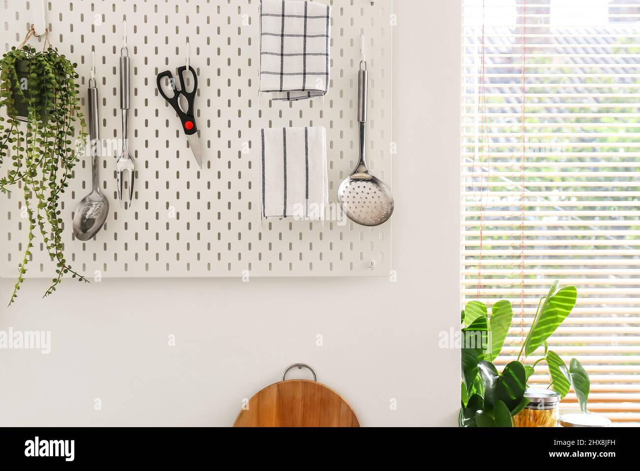 Pegboard With Modern Kitchen Utensils On White Wall Near Window Stock ... with regard to Pegboard Organization Kitchen
